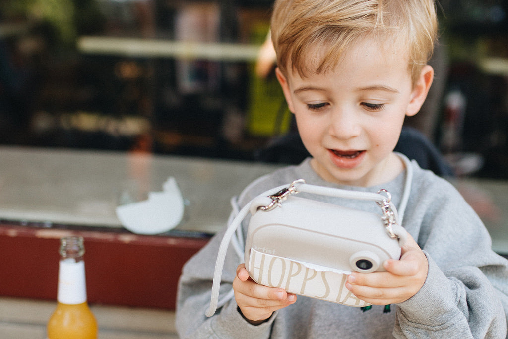 Ein Kind schaut auf das Display der Kinderkamera Artist Oat, um die aufgenommenen Bilder zu überprüfen oder das Motiv auszuwählen.