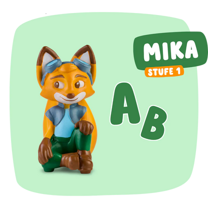 Die Figur Mika 'Erstes Lesen & Schreiben' steht neben einem ABC, um das erste Lesen und Schreiben zu fördern.