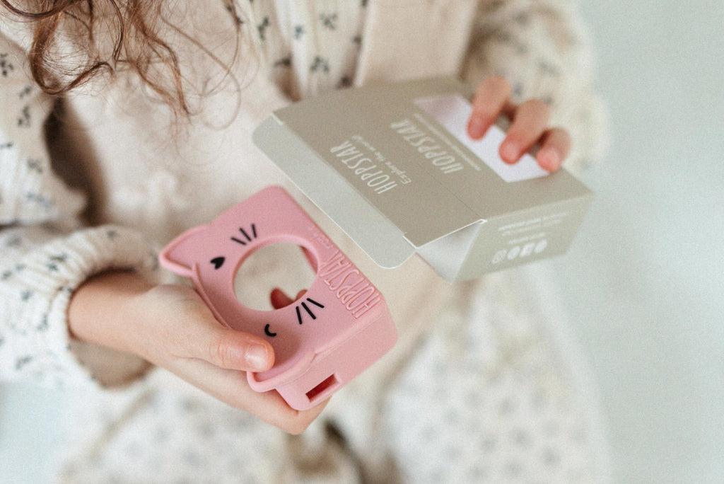 Kinderkamera in der 'Rookie Blush' Silikonhülle, die in der Hand gehalten wird, um die Benutzerfreundlichkeit und den sicheren Halt zu demonstrieren.