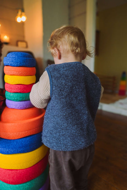  Kind steht vor dem Stapelstein® Original Mini rainbow classic 6er Set